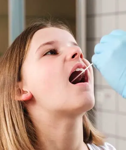 child getting swabbed for an at home DNA test